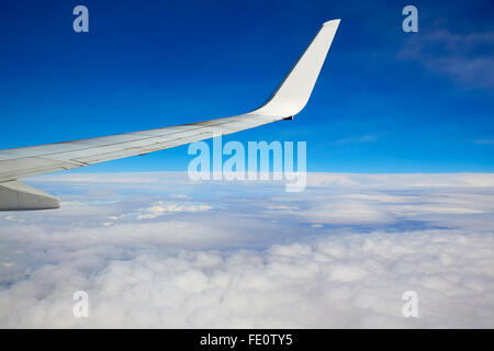Flugzeugflügel fliegen in einen blauen Himmel und Wolken Stockfoto