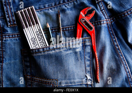 Lineal, Bleistift, Schraubenzieher, Rohrzange, in eine Jeans-Tasche Stockfoto