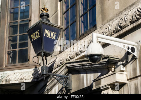 Eine moderne CCTV-Kamera neben einer traditionellen Polizei blaue Lampe Zeichen auf eine Polizeiwache in London. Stockfoto