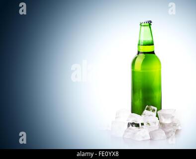 Bierflasche in Eiswürfel auf blauem Hintergrund Stockfoto