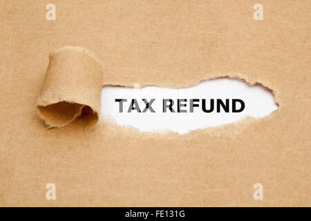 Der Text Tax Refund erscheint hinter braunes Papier zerrissen. Stockfoto