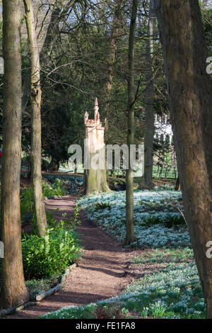 Schloss Baum Skulptur und Schneeglöckchen in Painswick Rokoko Gardens. Cotswolds, Gloucestershire, UK Stockfoto