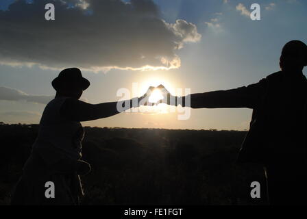 Ein Mann und eine Frau, die Hand in Hand in "A Love Herz in der Sonne" Stockfoto