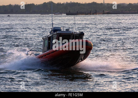 25' Defender Klasse uns Coast Guard RB-S Patrouillenboot springt über eine Welle auf dem Hudson River in New York City in der Abenddämmerung Stockfoto