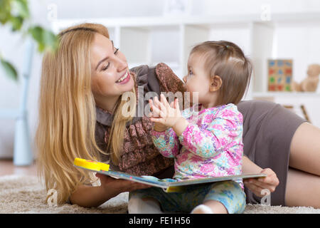 Kind Mädchen und Mutter lesen Sie ein Buch im Innenbereich Stockfoto