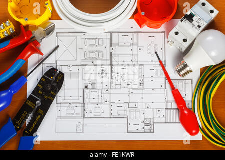 Elektrische Geräte, Werkzeuge und Hauspläne auf dem Schreibtisch Stockfoto