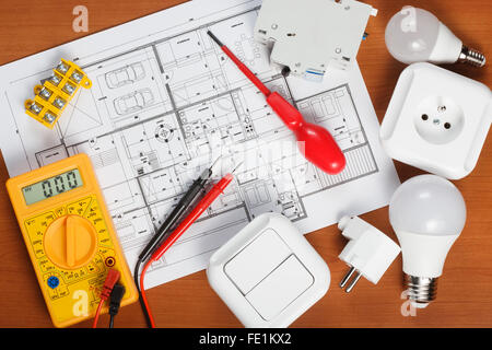 Elektrische Geräte, Werkzeuge und Hauspläne auf dem Schreibtisch Stockfoto