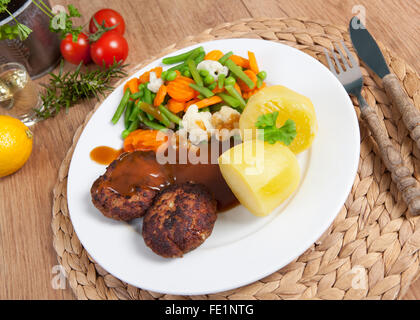 frittierte Fleischbällchen auf einem Teller mit Gemüse und Kartoffeln Stockfoto