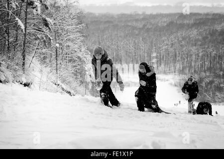 UFA - Russland 16. Januar 2016 - junge Teens Aufstieg bis zum Gipfel von einem hohen schneebedeckten Hügel nach einer erfolgreichen Rutschen auf m Stockfoto