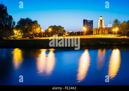 Sommernacht Blick auf Insel der Tränen, Insel des Mutes und der Trauer in Minsk, Weißrussland. Reflexion der Nacht Hintergrundbeleuchtung auf dem Wasser Stockfoto