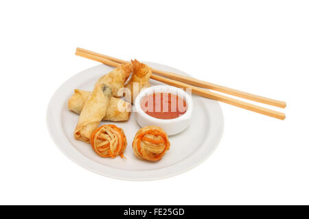 Auswahl an orientalische snacks auf einem Teller mit sweet Chili DIP-Sauce und Stäbchen auf dem Teller isoliert gegen weiß Stockfoto