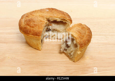 Huhn und Pilz Pie mit einer Scheibe ausgeschnitten auf einem Holzbrett Stockfoto