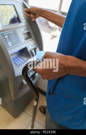 Mann mit Schädel-Hirn-Trauma mit einer Bank ATM Stockfoto