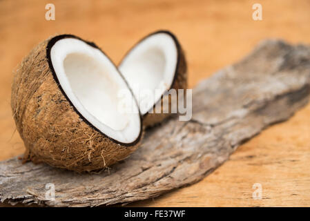 Alten Kokosnuss Cun auf hölzernen Hintergrund in zwei Teile mit negativen Raum Stockfoto