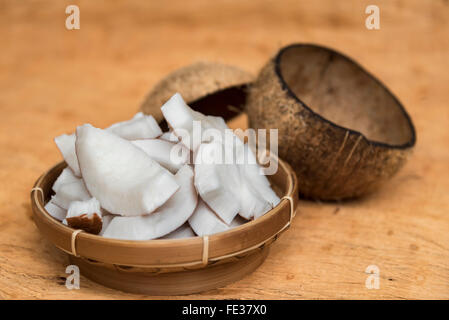 Alten Kokosnuss Cun auf hölzernen Hintergrund in zwei Teile mit negativen Raum Stockfoto