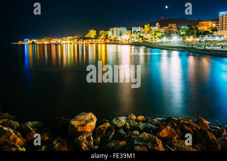 Nachtansicht Landschaft der Böschung, Küste, Strand In Benalmadena. Buntes Spiegelbild der Nachtbeleuchtung in ruhigem Wasser der Bucht. Stockfoto