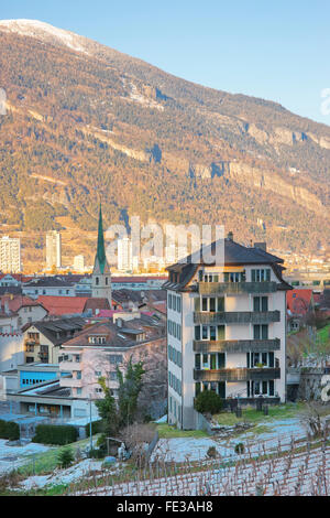 CHUR, Schweiz - 5. Januar 2015: St Martin Church und Alpen in Chur bei einem Sonnenaufgang. Chur ist die Hauptstadt des Kantons Graubünden in der Schweiz. Es liegt in der alpinen Bündner Rheintal. Stockfoto