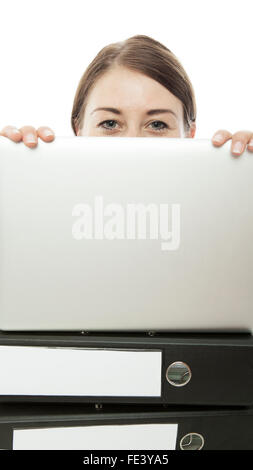 junge Frau versteckt sich hinter Notebook und Unterlagen Stockfoto