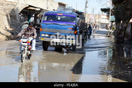 Pendler sind stagnierende Kanalisation Wasser eine unhygienische Atmosphäre schaffen wird, die auf der Durchreise und zeigt die Fahrlässigkeit der betroffenen Behörden, auf Barori Straße in Quetta auf Donnerstag, 4. Februar 2016. Stockfoto