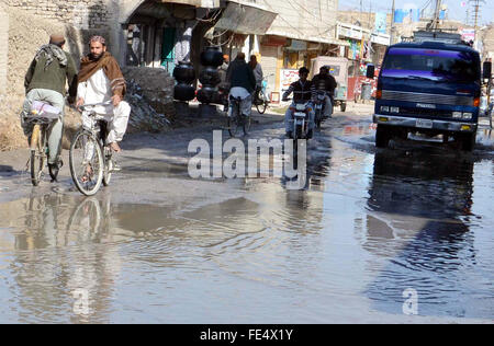 Pendler sind stagnierende Kanalisation Wasser eine unhygienische Atmosphäre schaffen wird, die auf der Durchreise und zeigt die Fahrlässigkeit der betroffenen Behörden, auf Barori Straße in Quetta auf Donnerstag, 4. Februar 2016. Stockfoto