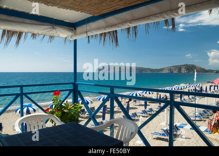 Sitzgelegenheiten im Lido bar mit Blick auf Sonnenliegen und Sonnenschirme am Strand Mingardo und Kap Palinuro, Cilento, Italien Stockfoto