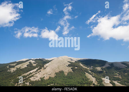 Die Karst-Bergkette des Monte Cervati unter blauem Himmel mit weißen Sommerwolken, Cilento, Kampanien, Italien Stockfoto