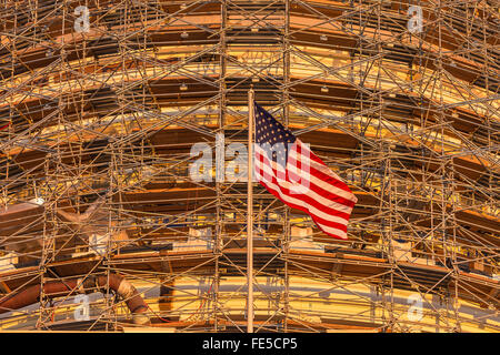 Die Flagge der Vereinigten Staaten von Amerika fliegt vor der Scaffodling für die United States Capitol Dome Restaurierung Jubiläumsfeierlichkeiten Stockfoto