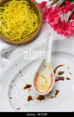 Lust auf asiatisch, chinesisches Essen, Hunger, gelbe Noodle Bowl, leeren Teller, schmutziges Geschirr, Stockfoto