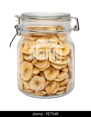 Getrocknete Bananenchips in einem Glas-Kanister mit einer Metallklemme. Das Bild zeigt einen Ausschnitt isoliert auf einem weißen Hintergrund. Stockfoto