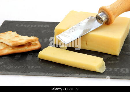 Frisch geschnittene Cheddar Käse mit Crackern auf einer Schiefertafel Tafel Stockfoto