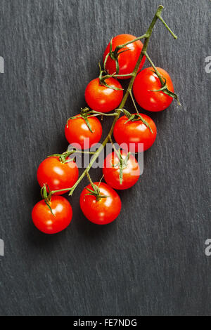 Cherry-Tomaten auf einer schwarzen Tafel Stockfoto