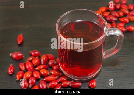 Hundsrose Tee auf schwarzer Holztisch Stockfoto