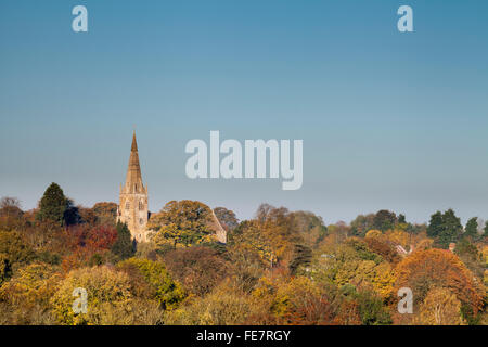 Die sächsischen Allerheiligen-Kirche erhebt sich über herbstliche Bäume im Dorf Brixworth in Northamptonshire, England. Stockfoto