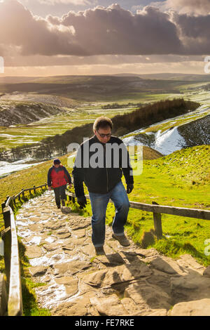 Wanderer erklimmen die Steintreppe führt vom Parkplatz bis zum Gipfel des Mam Tor. Stockfoto