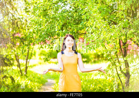 asiatische Frau werfen Blütenblätter im Frühlingsgarten Stockfoto