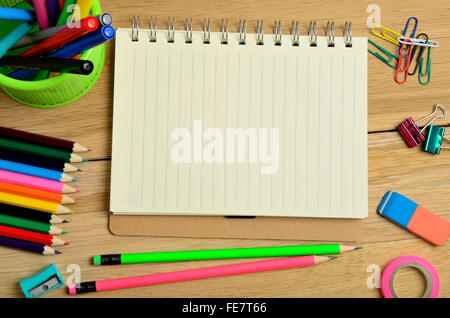 Leere Arbeitsmappe und bunte Bleistifte auf Holztisch Stockfoto