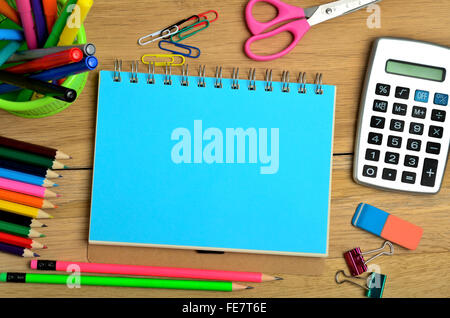 Notizblock mit bunten Bleistift und Taschenrechner auf Schreibtisch Stockfoto