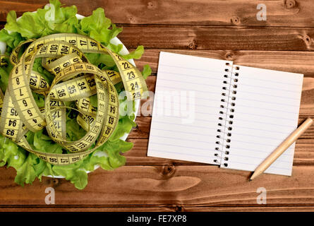 Gemüsesalat mit Notebook auf Holztisch Stockfoto