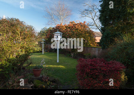 Dekorative hölzerne Taubenschlag in einem vorstädtischen Garten mit Zwergmispel Baum und Strauch voll von roten Beeren, Northampton, England Stockfoto