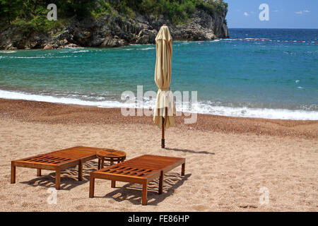 Zwei hölzerne Stühle am leeren Strand in Sveti Stefan, Montenegro Stockfoto