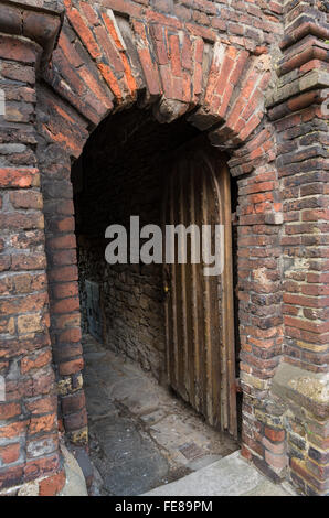 Historischen Backstein Torbogen und Holztür im alten Gymnasium, Roggen High Street, Sussex UK, von Thomas Peacocke 1636 gegründet. Stockfoto