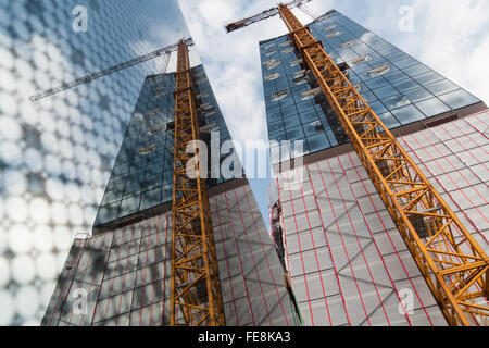 Nachschlagen der Fassade und ein Kran und ihre Reflexion in einem Fenster-Glas-Element, Baustelle des Elbphilhamonie, Hamburg Stockfoto