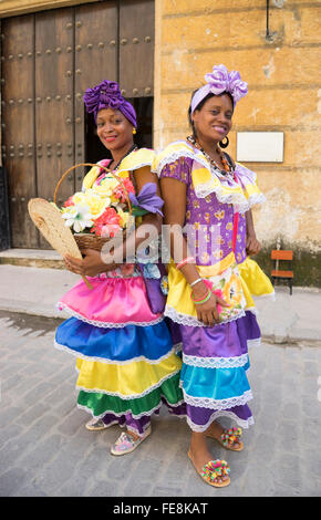 zwei kubanische Frauen in bunten Kleidern posieren für Fotos auf der Straße von Havanna, Kuba Stockfoto