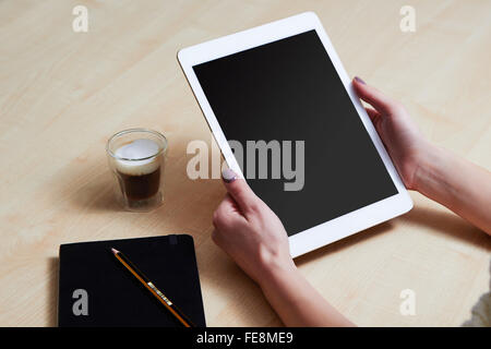 Frau-Sing-Tablet-pc an der Rezeption, leerer Bildschirm Stockfoto