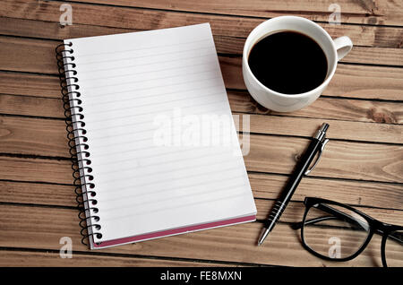 Tasse Kaffee und Notizblock auf Tisch Stockfoto