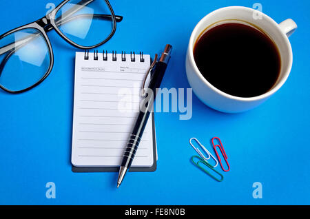 Notizblock mit Kaffeetasse auf Hintergrund Stockfoto