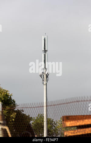 Handy-Turm gegen bedecktem Himmel mit rostendem Stahl im Vordergrund. Stockfoto