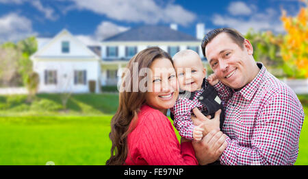 Glückliche junge Familie mit Baby im Freien vor schönen individuelles Haus. Stockfoto