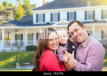 Glückliche junge Familie mit Baby im Freien vor schönen individuelles Haus. Stockfoto