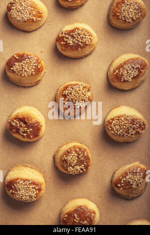 Frische hausgemachte salzig Scones mit Käse und Sesam, lecker Backen Lebensmittelprodukt auf Kraftpapier, Ansicht von oben. Stockfoto